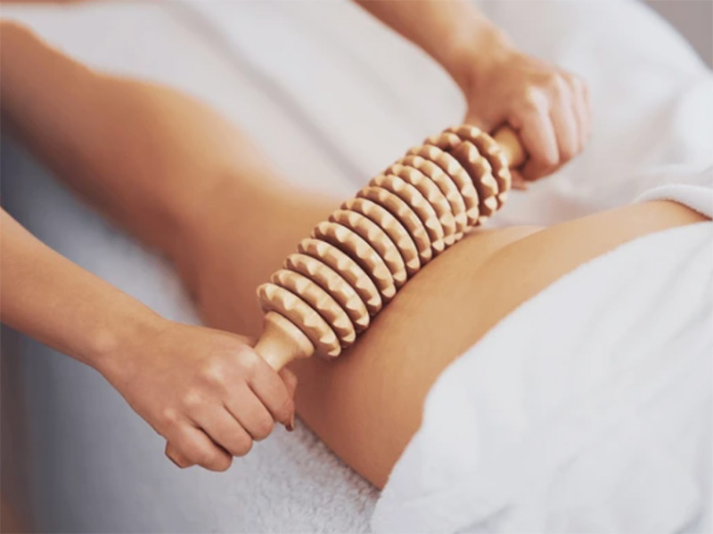 masaža noge drvenim maderoterapijskim valjkom